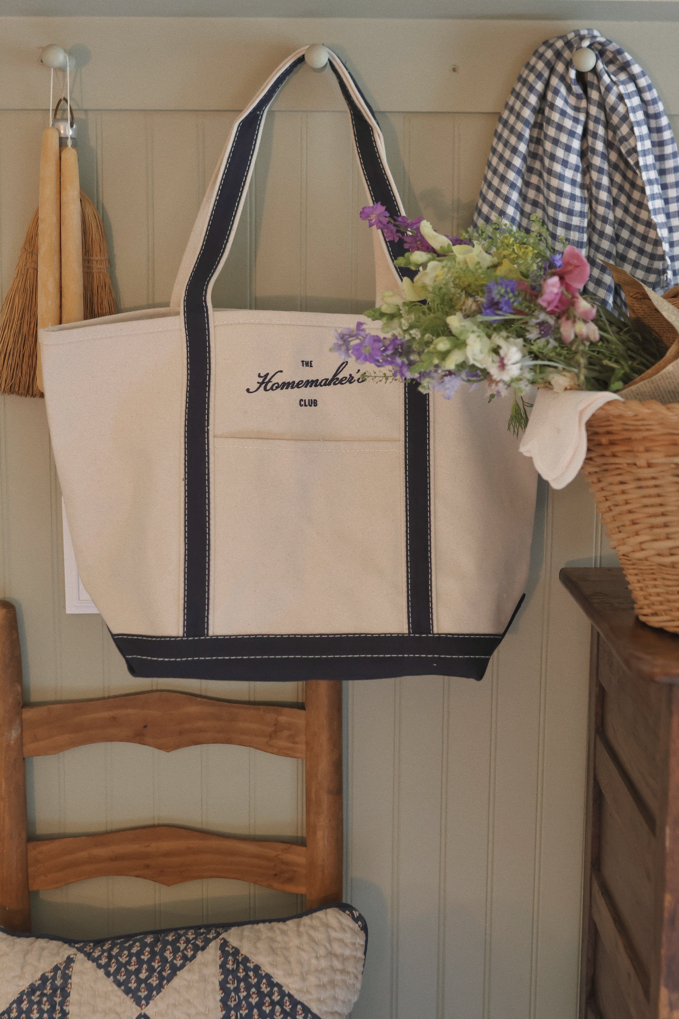 Natural canvas boat tote with navy trim and embroidered Homemaker’s Club logo