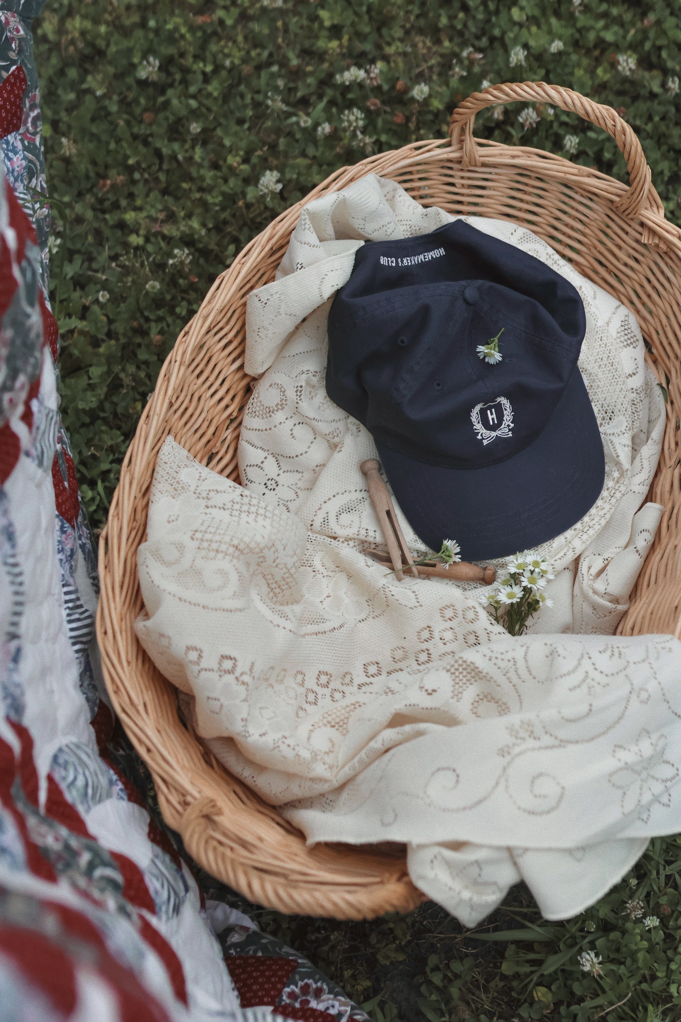 Navy cotton dad cap with cream embroidered Signature Homemaker's Club Crest on front and Homemaker's Club embroidered on back.